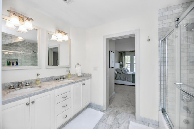 full bathroom featuring a tile shower, baseboards, marble look tile flooring, double vanity, and connected bathroom