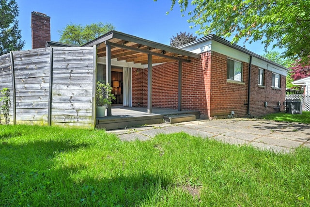 11837 Meteor Dr, Sterling Heights, MI 48313 - back of house featuring a chimney and central AC unit
