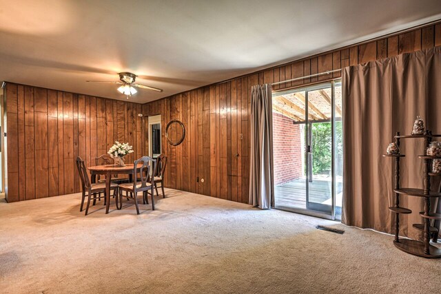 11837 Meteor Dr, Sterling Heights, MI 48313 - carpeted dining area featuring wooden walls and a ceiling fan