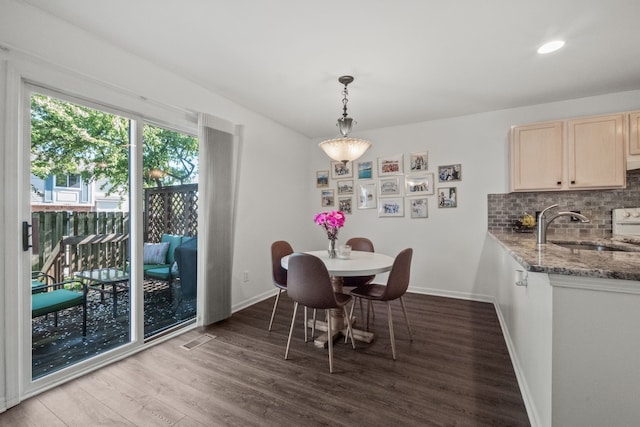 dining space with baseboards, wood finished floors, and recessed lighting