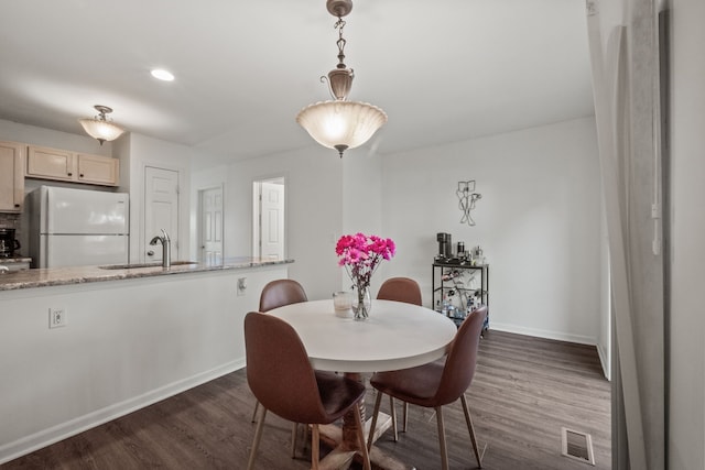 dining area featuring dark wood-type flooring and baseboards