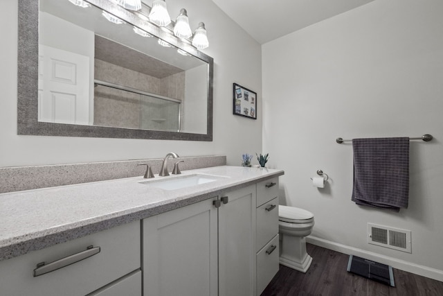 full bathroom with baseboards, a shower stall, toilet, wood finished floors, and vanity