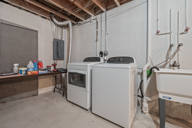 clothes washing area with electric panel and washing machine and dryer