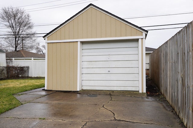 detached garage with fence and driveway