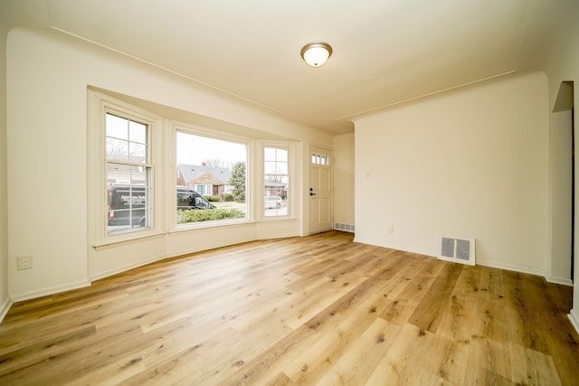 unfurnished room with light wood finished floors and baseboards