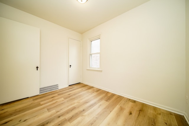 spare room with light wood-style flooring and baseboards