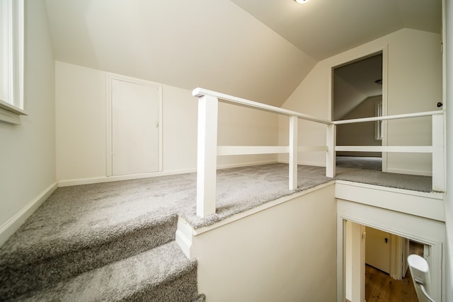 additional living space featuring vaulted ceiling and baseboards