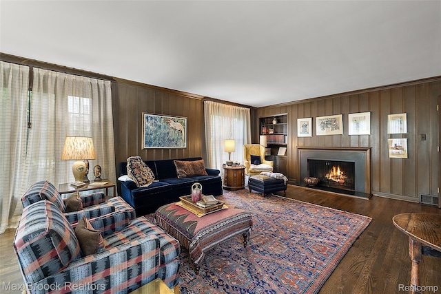 3287 Bradway Blvd, Bloomfield Hills, MI 48301 - living room with wooden walls, built in features, a warm lit fireplace, and wood finished floors