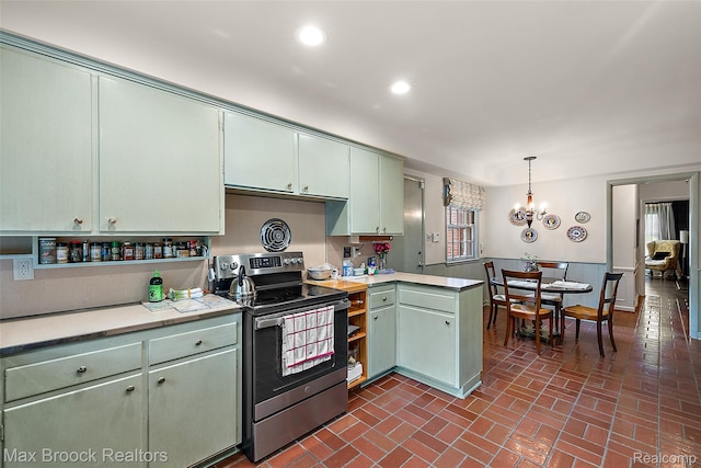 3287 Bradway Blvd, Bloomfield Hills, MI 48301 - kitchen featuring stainless steel range with electric stovetop, brick patterned floors, light countertops, decorative light fixtures, and a chandelier