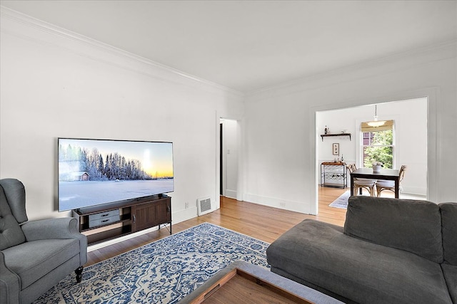 living room featuring crown molding, wood finished floors, and baseboards