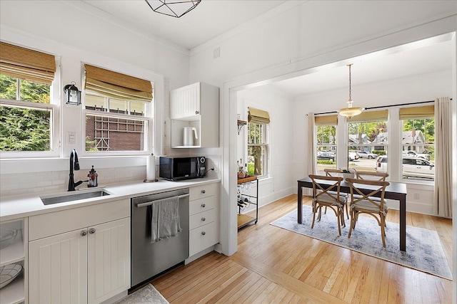 kitchen with dishwasher, a sink, black microwave, white cabinets, and backsplash