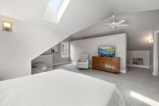 bedroom featuring vaulted ceiling, carpet, baseboards, a ceiling fan, and a skylight