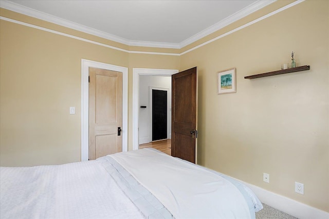 bedroom featuring ornamental molding, baseboards, and carpet flooring