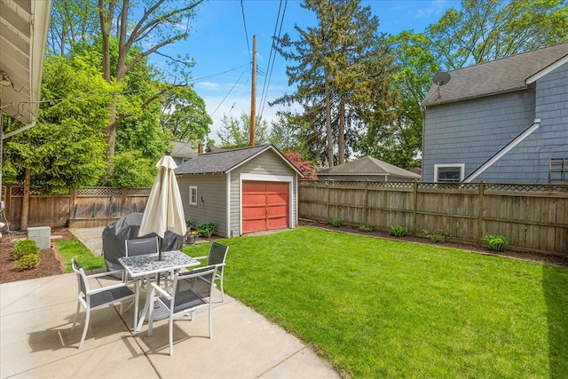 view of yard featuring a patio, a garage, an outbuilding, and outdoor dining space