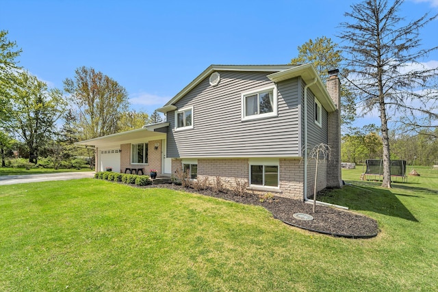 9703 Tower Rd, South Lyon, MI 48178 - tri-level home featuring a chimney, a garage, a front yard, and driveway