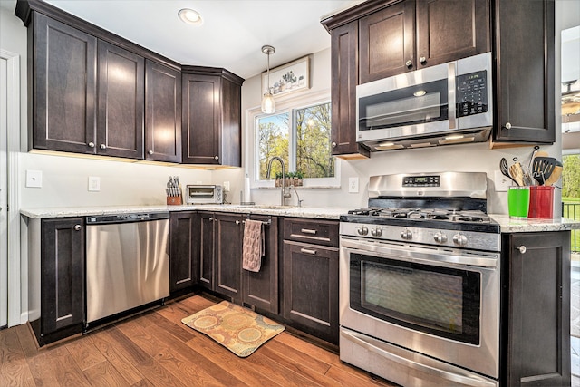 9703 Tower Rd, South Lyon, MI 48178 - kitchen with stainless steel appliances, dark wood-type flooring, dark brown cabinetry, a sink, and recessed lighting