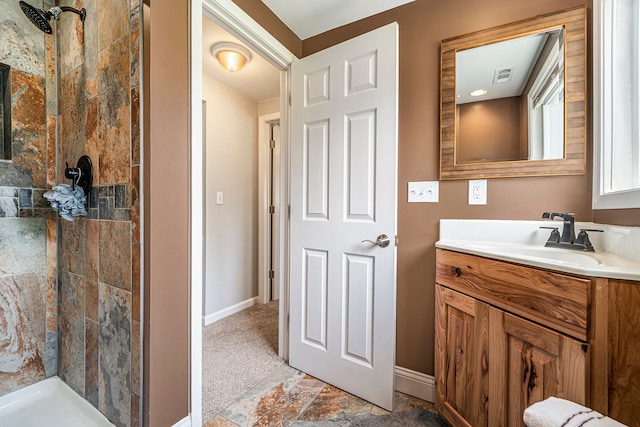9703 Tower Rd, South Lyon, MI 48178 - full bathroom with a tile shower, vanity, baseboards, and stone finish floors