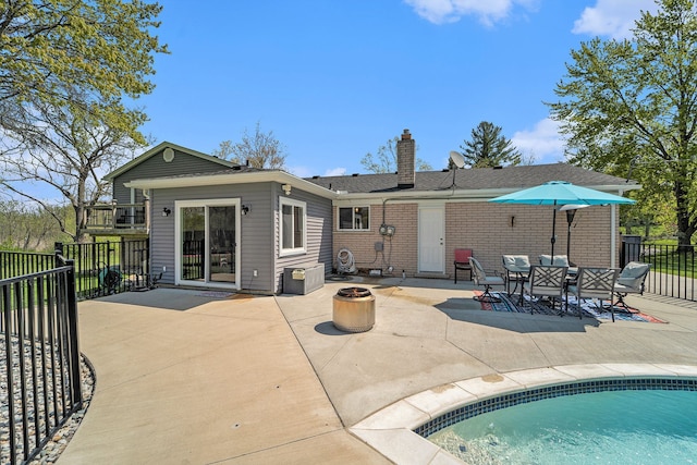 9703 Tower Rd, South Lyon, MI 48178 - rear view of house featuring a fire pit, a patio, fence, and a chimney