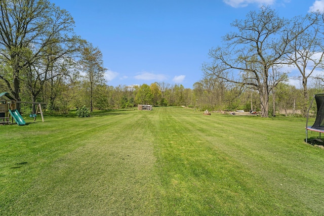 9703 Tower Rd, South Lyon, MI 48178 - view of grassy yard with a trampoline and a playground