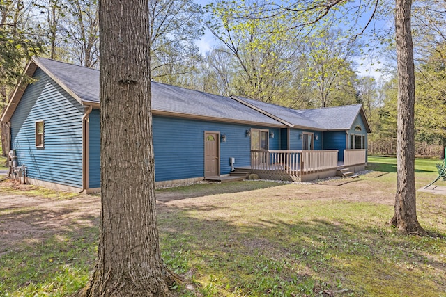 8869 E Hawley Rd, Hesperia, MI 49421 - view of front facade featuring a wooden deck, a front lawn, and roof with shingles