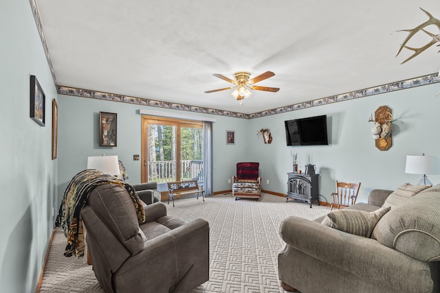 8869 E Hawley Rd, Hesperia, MI 49421 - living room with light carpet, a wood stove, ceiling fan, and baseboards