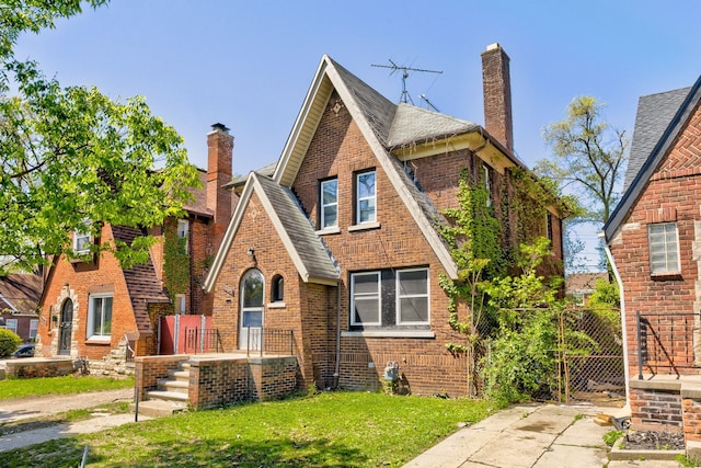 18613 Santa Rosa Dr, Detroit, MI 48221 - english style home with brick siding, a chimney, a shingled roof, and a front lawn
