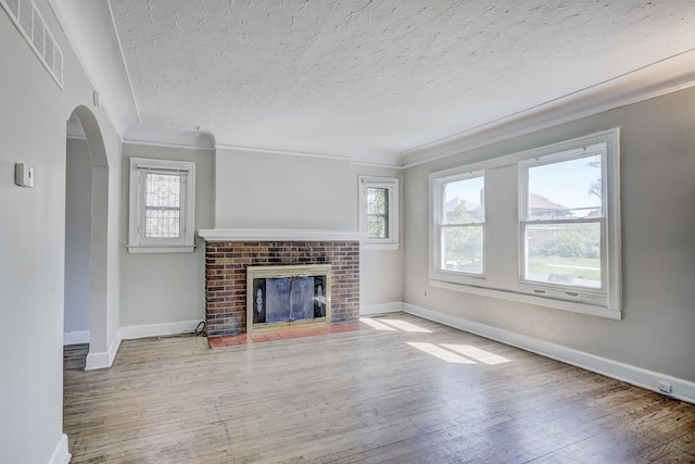 18613 Santa Rosa Dr, Detroit, MI 48221 - unfurnished living room with plenty of natural light, hardwood / wood-style floors, arched walkways, a textured ceiling, and baseboards