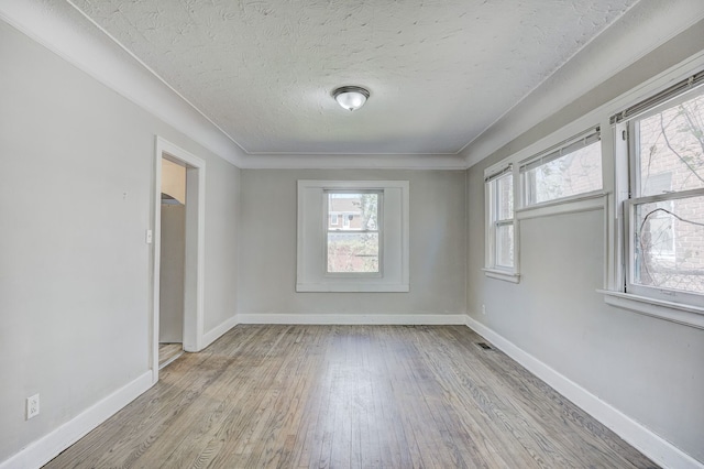 18613 Santa Rosa Dr, Detroit, MI 48221 - unfurnished room with light wood-style flooring, a textured ceiling, and baseboards