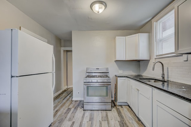 18613 Santa Rosa Dr, Detroit, MI 48221 - kitchen featuring freestanding refrigerator, stainless steel gas stove, a sink, and light wood-style flooring