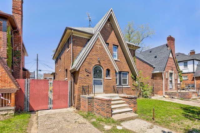18613 Santa Rosa Dr, Detroit, MI 48221 - tudor house with brick siding, a gate, and fence