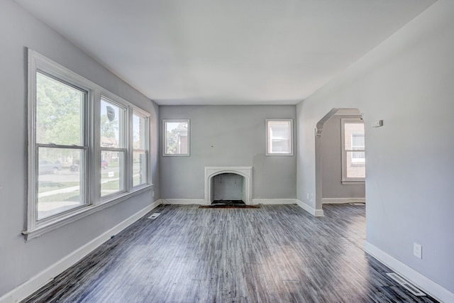 18644 Santa Rosa Dr, Detroit, MI 48221 - unfurnished living room with arched walkways, dark wood-style floors, a fireplace, and baseboards