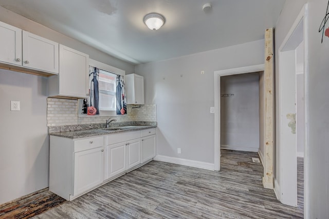 18644 Santa Rosa Dr, Detroit, MI 48221 - kitchen with white cabinets, wood finished floors, and backsplash