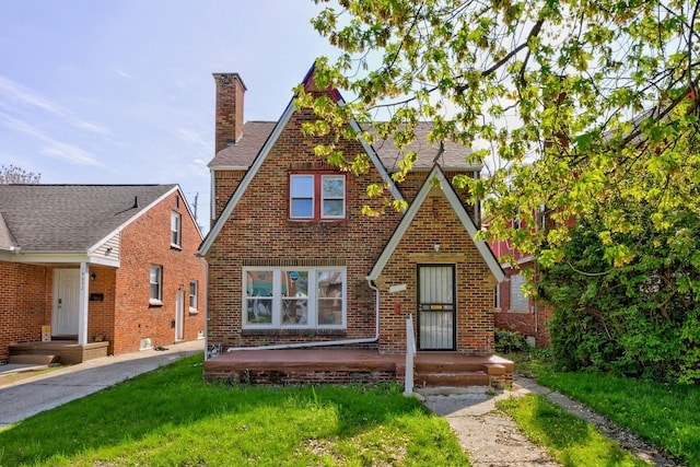 18644 Santa Rosa Dr, Detroit, MI 48221 - english style home featuring a chimney, brick siding, a front lawn, and a shingled roof