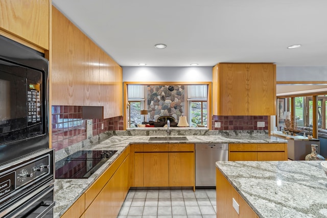 kitchen with black appliances, a sink, plenty of natural light, and backsplash