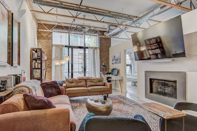 111 N Main St Unit 209, Royal Oak, MI 48067 - living room featuring a fireplace, a high ceiling, and brick wall