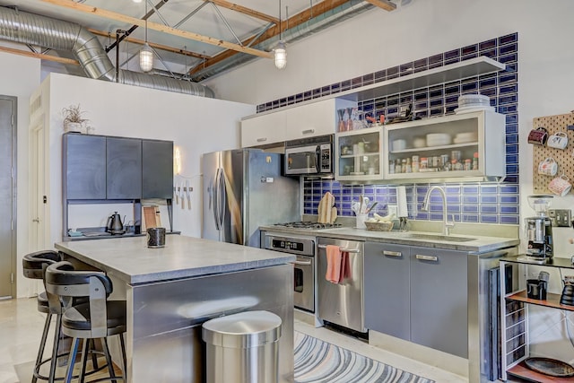 111 N Main St Unit 209, Royal Oak, MI 48067 - kitchen with a sink, appliances with stainless steel finishes, a breakfast bar, a kitchen island, and glass insert cabinets