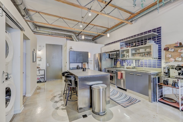 111 N Main St Unit 209, Royal Oak, MI 48067 - kitchen featuring a sink, appliances with stainless steel finishes, estacked washer and dryer, a high ceiling, and light countertops