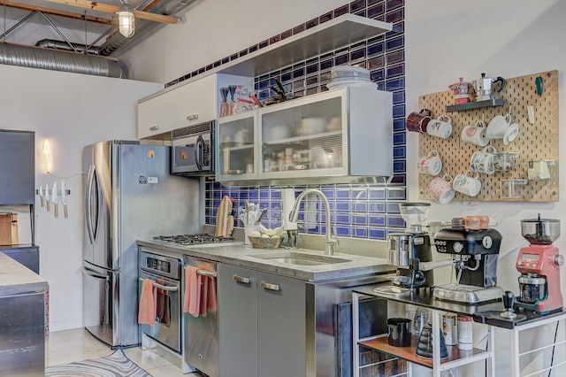 111 N Main St Unit 209, Royal Oak, MI 48067 - kitchen with a sink, oven, tasteful backsplash, open shelves, and glass insert cabinets