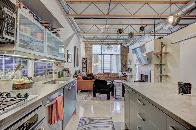 111 N Main St Unit 209, Royal Oak, MI 48067 - kitchen featuring a sink, stainless steel appliances, gray cabinets, finished concrete flooring, and a high ceiling
