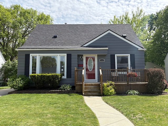 view of front of house featuring roof with shingles and a front lawn