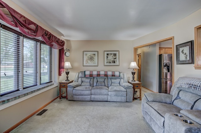 living area with light carpet and baseboards