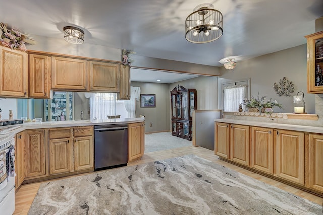 kitchen with dishwasher, light countertops, light wood finished floors, and plenty of natural light