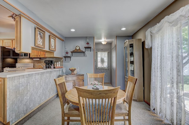 dining room featuring light colored carpet, plenty of natural light, and recessed lighting