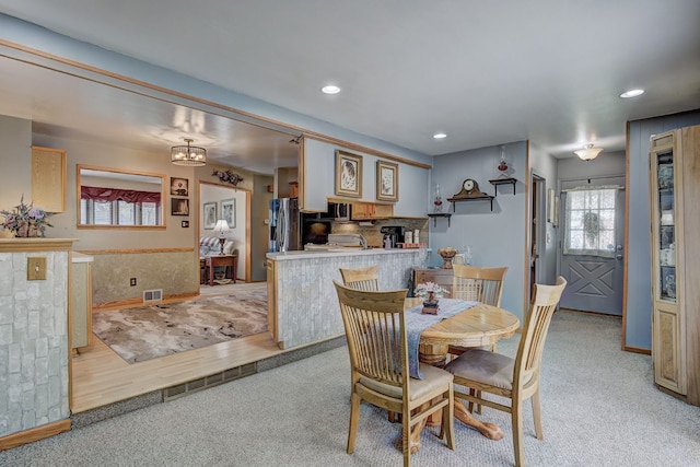 dining room featuring light colored carpet, recessed lighting, and baseboards