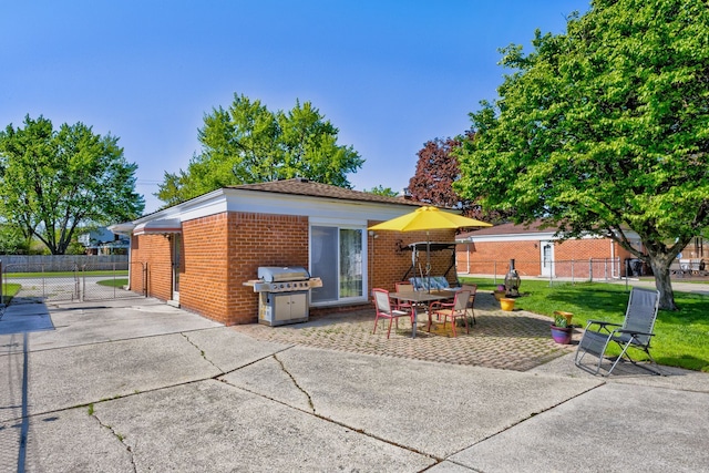 rear view of house with brick siding, a patio, and fence