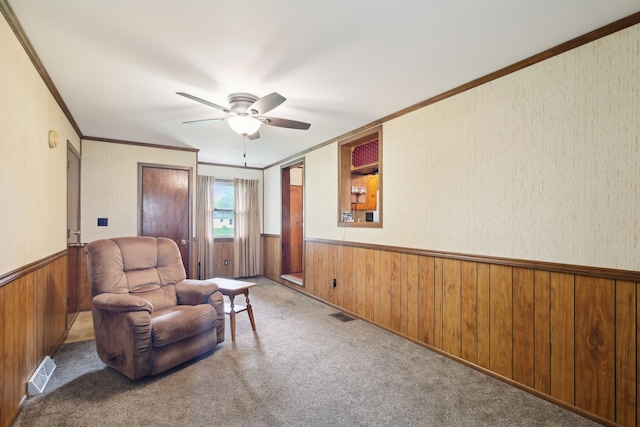 5427 Fiesta Pass, Grand Blanc, MI 48439 - living area with a wainscoted wall, crown molding, wooden walls, ceiling fan, and carpet
