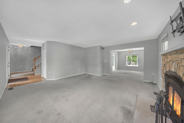 137 Donna, Waterford, MI 48327 - unfurnished living room with a chandelier, a stone fireplace, stairway, carpet, and recessed lighting