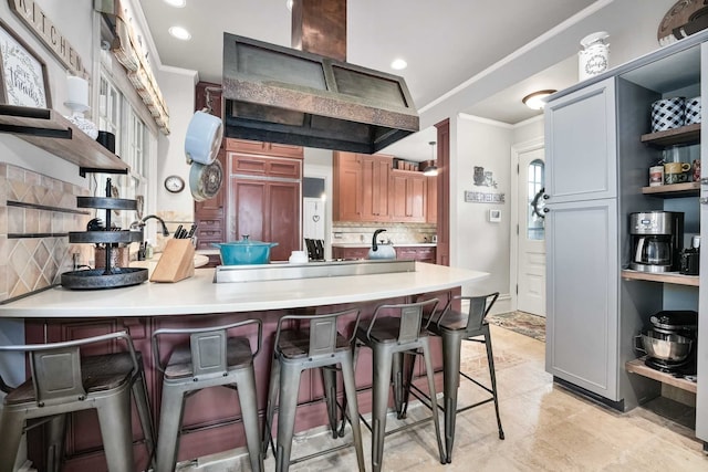 529 Fountain St NE, Grand Rapids, MI 49503 - kitchen featuring open shelves, crown molding, a peninsula, backsplash, and a breakfast bar