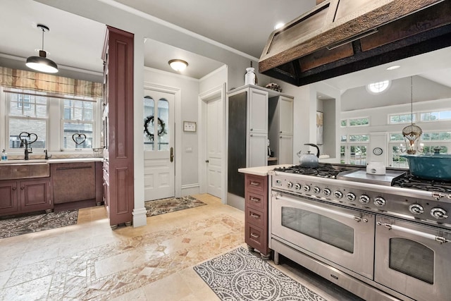 529 Fountain St NE, Grand Rapids, MI 49503 - kitchen with range with two ovens, light countertops, hanging light fixtures, ornamental molding, and a sink