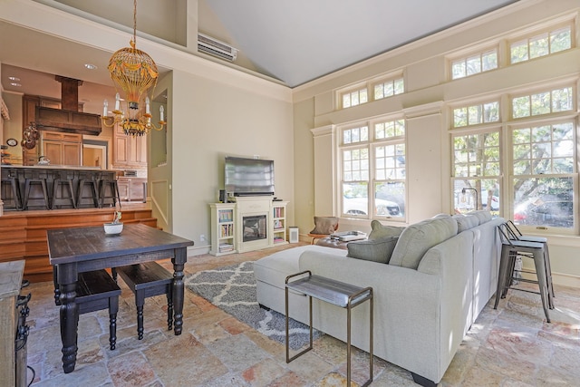 529 Fountain St NE, Grand Rapids, MI 49503 - living area featuring high vaulted ceiling, a chandelier, stone tile flooring, and a glass covered fireplace